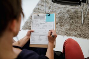 Adult patient completing an ADHD assessment questionnaire during a psychiatric evaluation appointment.