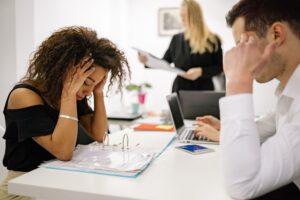 Adults experiencing concentration and focus difficulties while managing work responsibilities in an office environment.